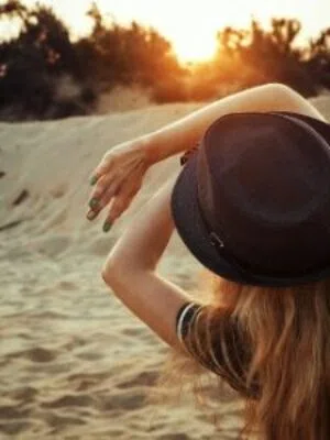 Sun exposure A woman who is afraid of getting spider veins shields her face from the sun.