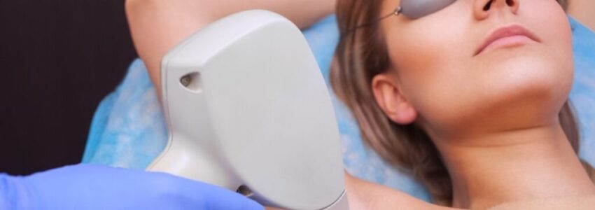The cosmetologist does the laser hair removal procedure