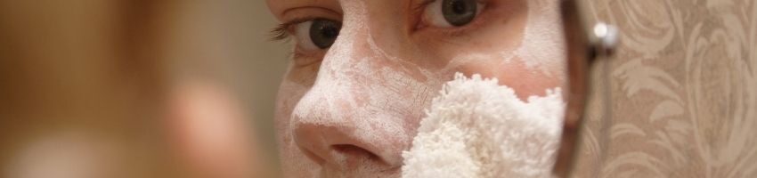 A woman applying acne moisturizer to her face