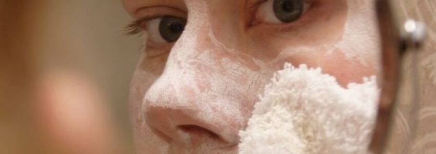 A woman applying acne moisturizer to her face