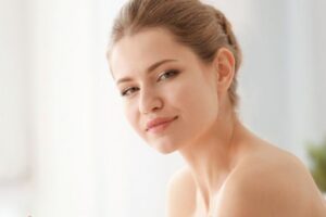 Female Applying Facial Moisturizer to her skin to prevent acne