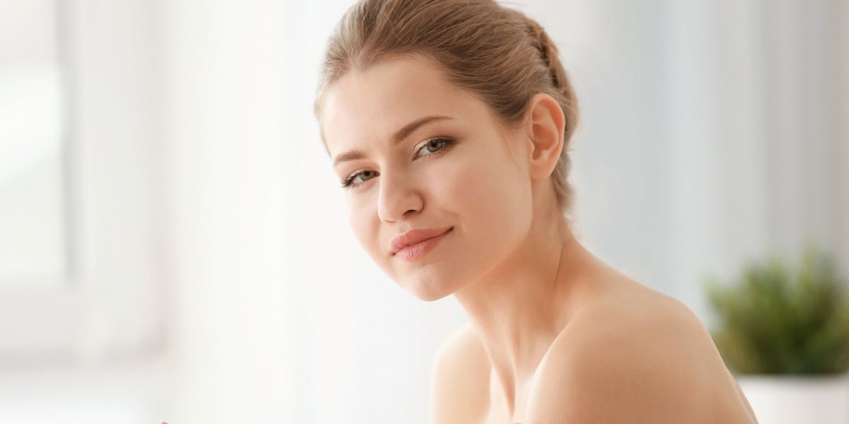 Female Applying Facial Moisturizer to her skin to prevent acne