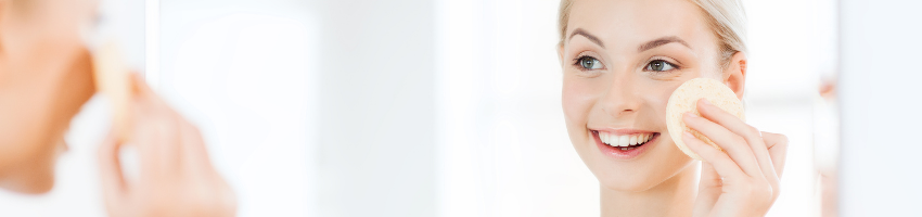 Teen age woman smiling infront of the mirror and happy for her glowing skin