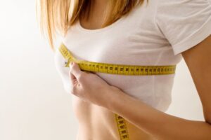 a woman measuring her breast using a steeltape