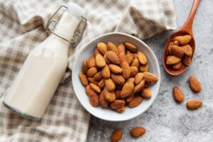 A bowl of almonds and a bottle of milk.