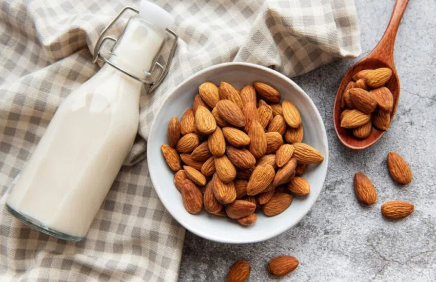 A bowl of almonds and a bottle of milk. 