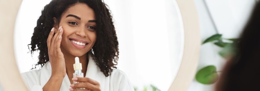 The woman is using skincare to remove dark spots on her black skin.