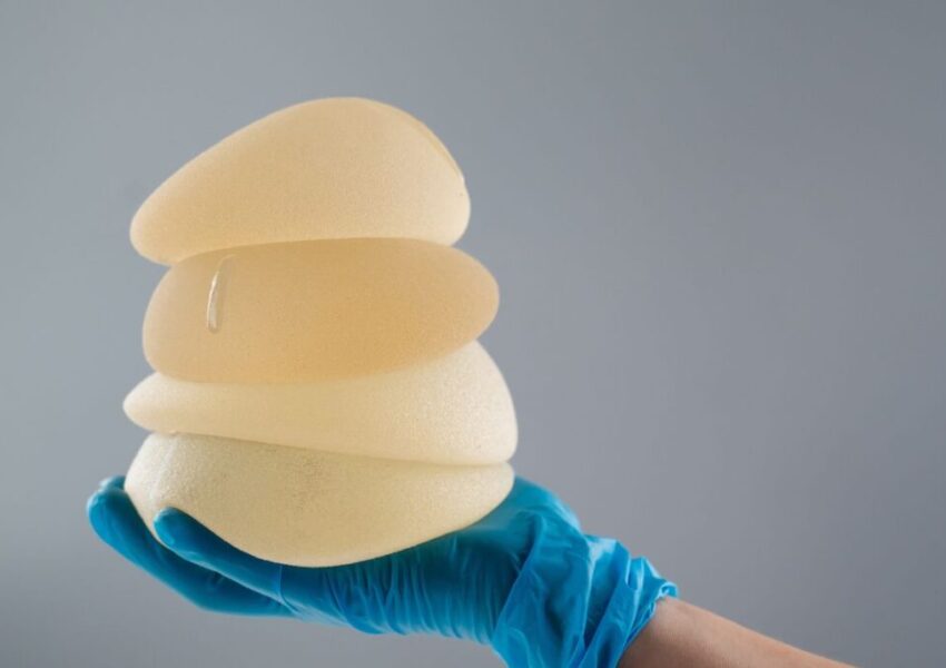 The surgeon held the different sizes of breast implants.