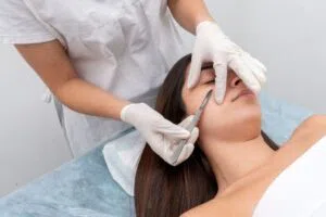 The woman tries dermaplaning to have smooth skin.