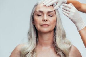 Aging woman receiving a botox shot, highlighting one of the commonly used botox injection sites.