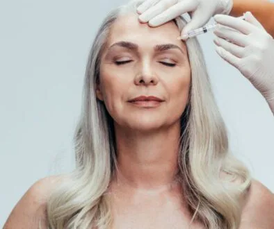 Aging woman receiving a botox shot, highlighting one of the commonly used botox injection sites.